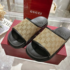 Gucci slide sandals on box: beige GG canvas straps and black textured slide soles