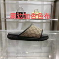 Gucci slide sandals with beige GG canvas strap and black rubber sole, open toe