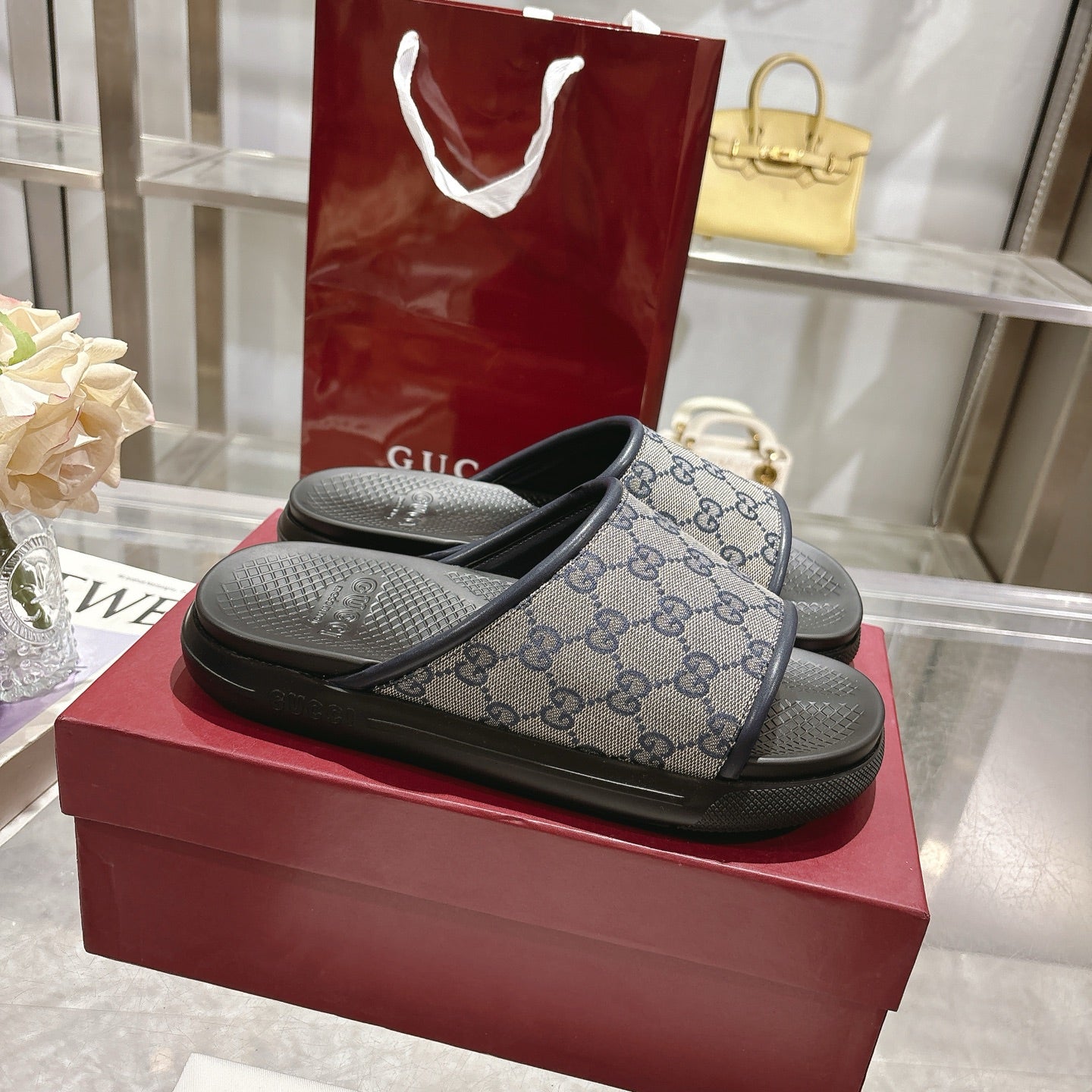 Gucci slide sandals with GG monogram strap and black textured rubber footbed