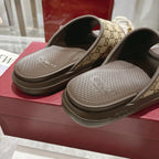 Gucci GG slide sandals close-up, tan monogram straps with dark lining