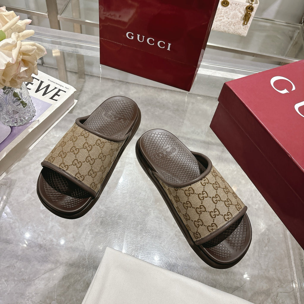 Gucci GG slide sandals pair, tan canvas bands with dark rubber soles