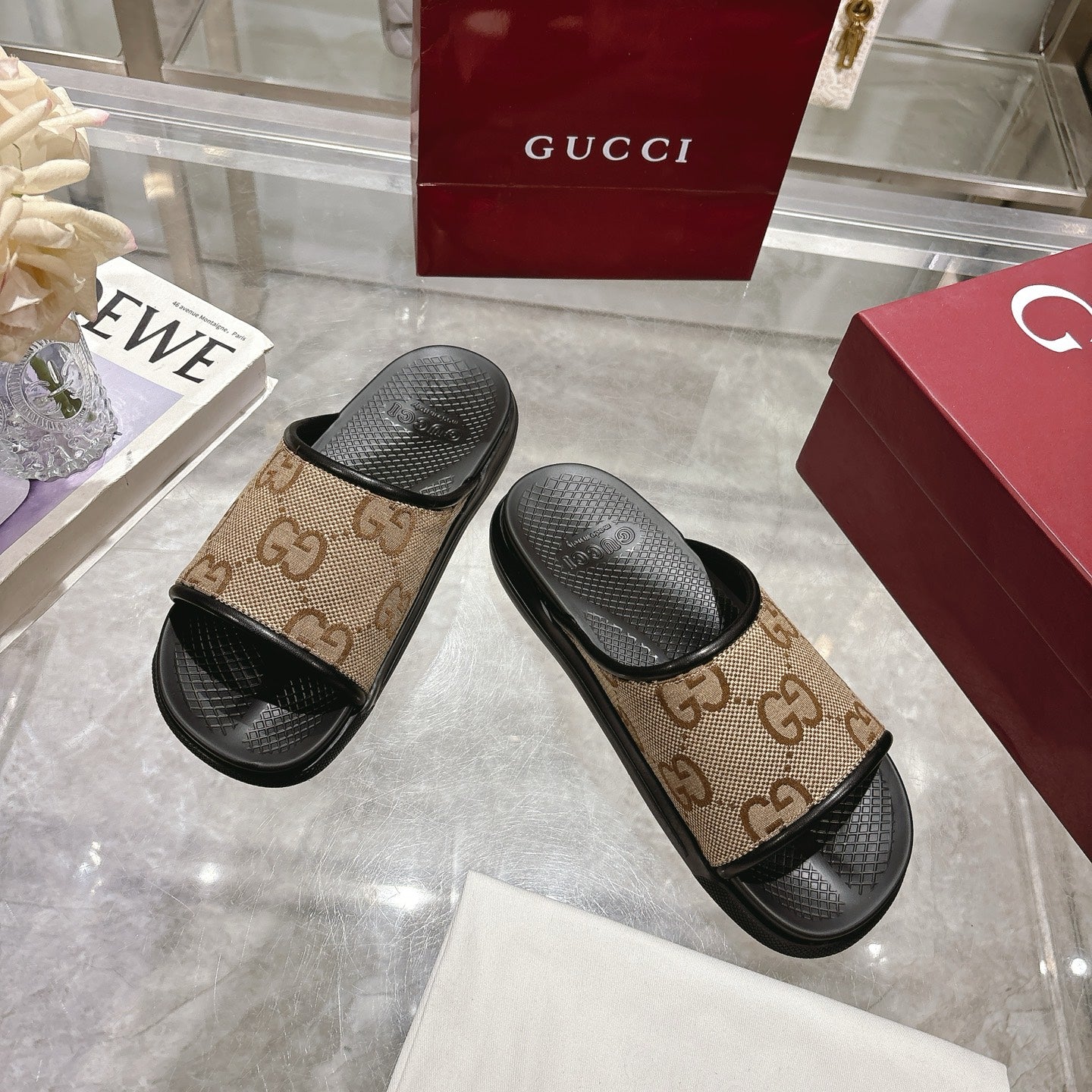 Gucci slide sandals showing tan GG canvas upper with black textured footbeds