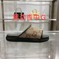 Gucci slide sandals with tan GG canvas straps and black rubber sole