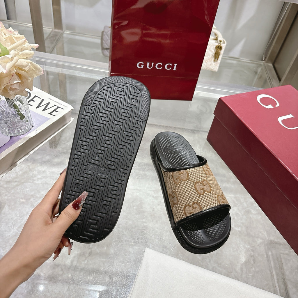 Gucci slide sandals outsole view with textured black tread and tan GG strap top