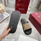 Gucci slide sandals outsole view with textured black tread and tan GG strap top