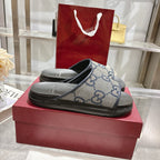 Gucci slide sandals with GG monogram upper and black rubber footbed, blue and cream.