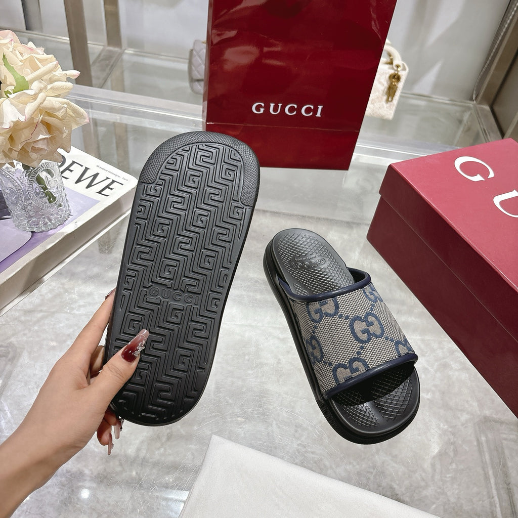 Gucci slide sandal sole view, black textured outsole with GG monogram side strap.