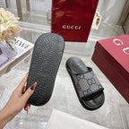 Gucci slide sandal sole view, black textured outsole with GG monogram side strap.