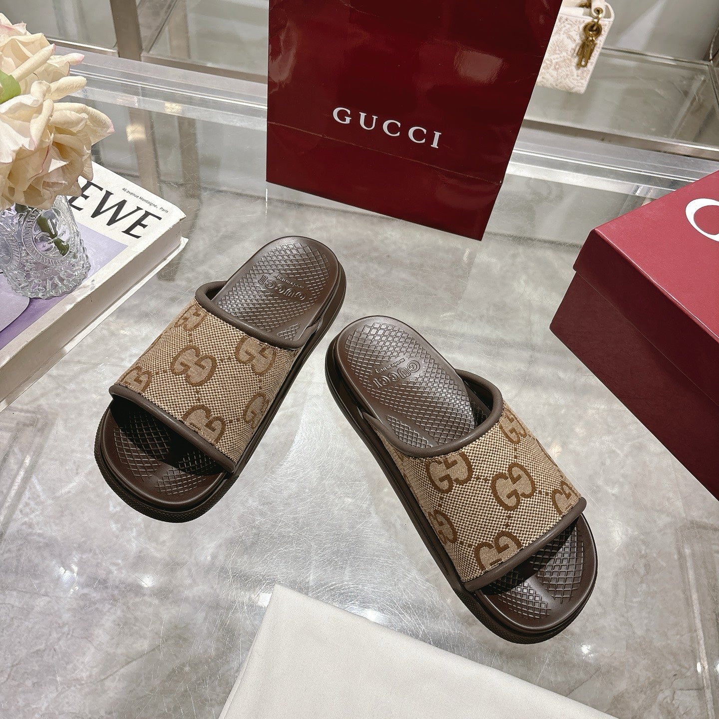 Beige GG canvas slide sandals with dark rubber trim and textured footbeds