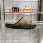 Beige GG canvas slide sandals with dark rubber sole, cushioned footbed