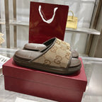 Beige GG canvas slide sandals with dark sole, cushioned footbed, pair view