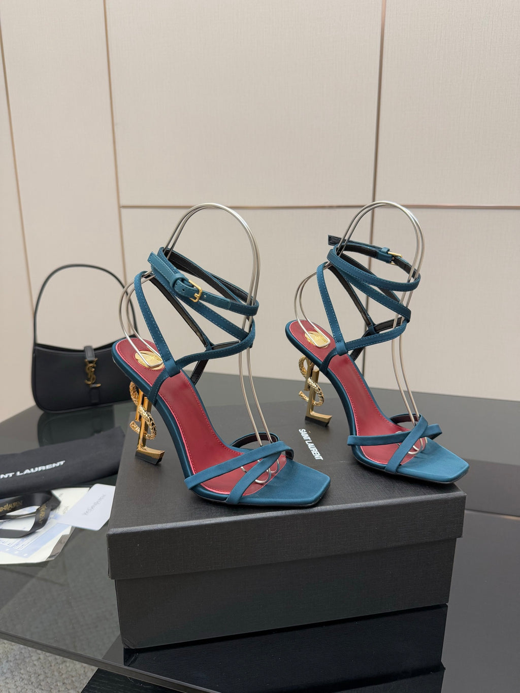 YSL ladies’ strappy heeled sandals on display, blue with red trim and gold accents