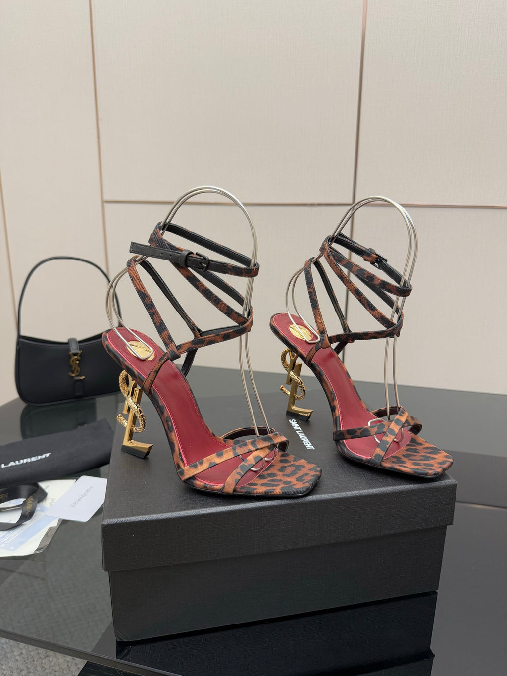 Leopard print strappy high-heel sandals with gold logo heels and black ankle straps