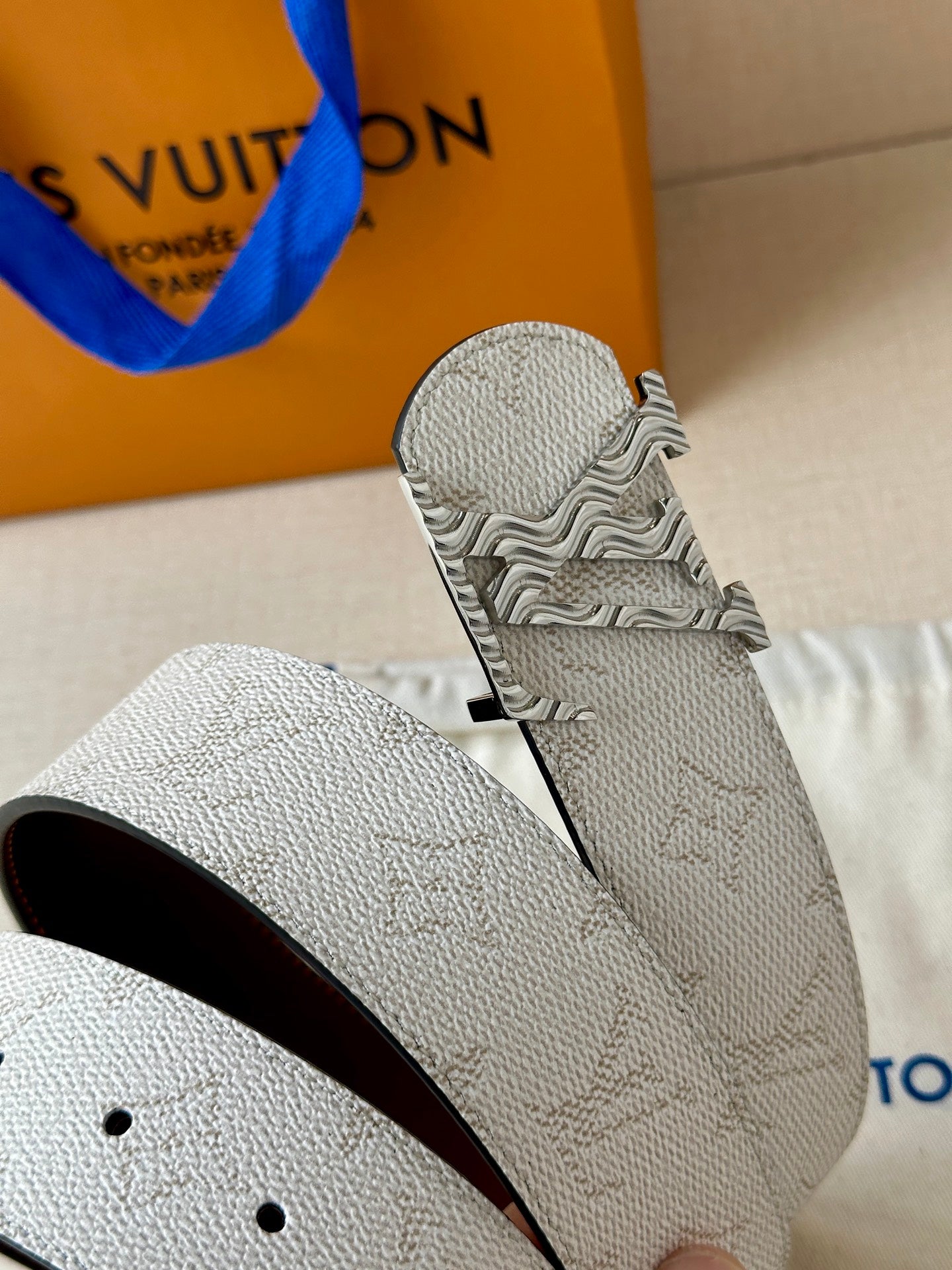 Louis Vuitton belt end: light gray textured strap with dark brown inner edge