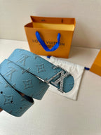 Blue monogram belt with gold buckle and black inner strap, close view.