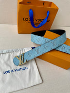 Blue monogram belt with gold buckle, with pouch and orange packaging.