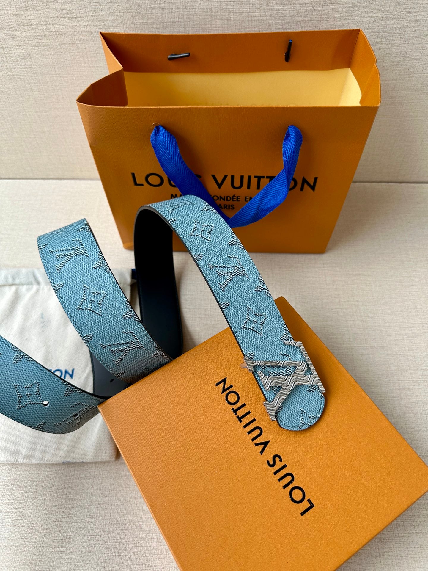Blue monogram belt with gold buckle and black underside, with box and bag.