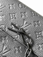 Textured leather crossbody bag with engraved metal clasp and monogram pattern