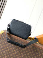 Dark monogram leather crossbody bag with front flap, crossbody strap, and hardware