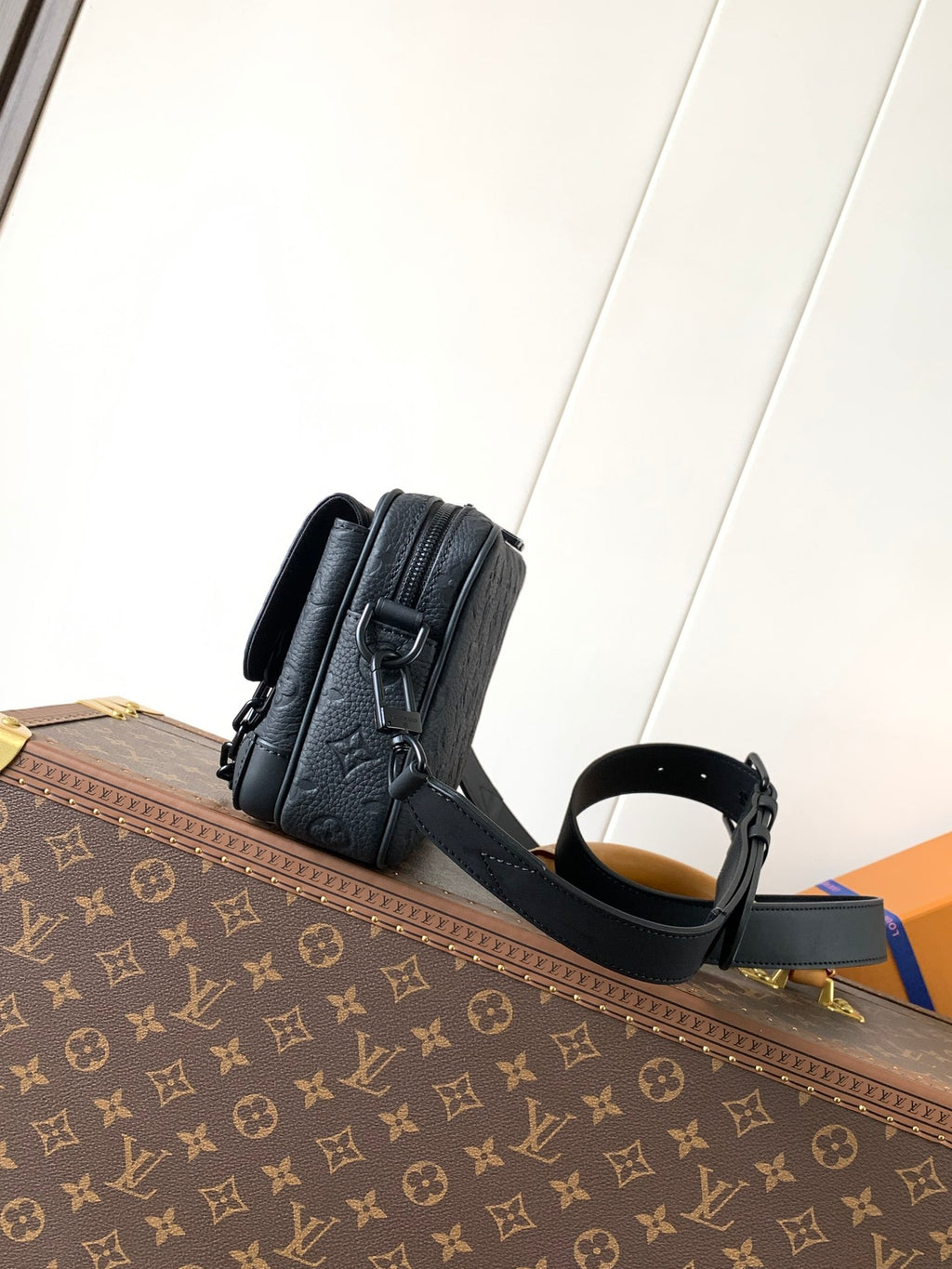Dark leather crossbody bag with top handle, zipper, and adjustable strap