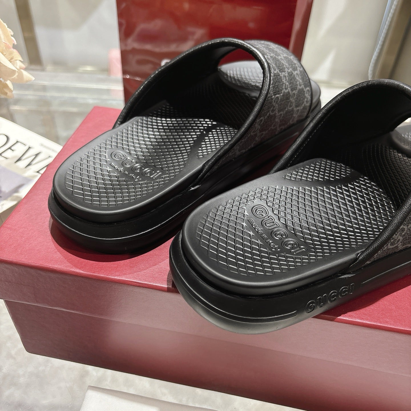 Monogram slide sandals showing textured tread footbeds and dark patterned straps
