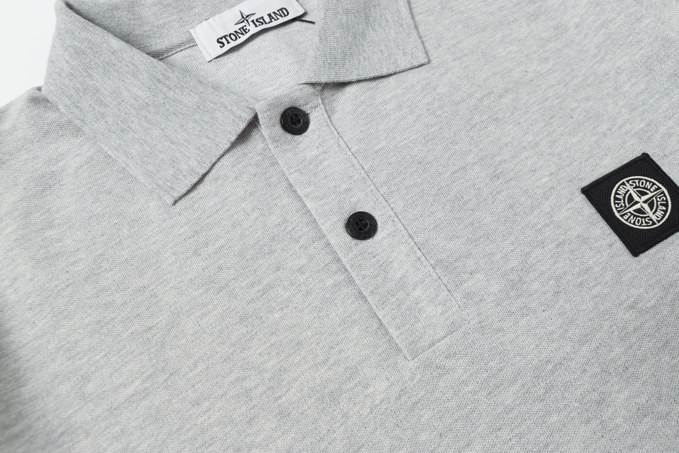 Light gray polo shirt front with black buttons and side logo patch