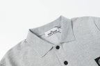 Light gray polo shirt collar with black buttons and tag