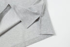 Light gray polo shirt hem with side seam and button placket detail