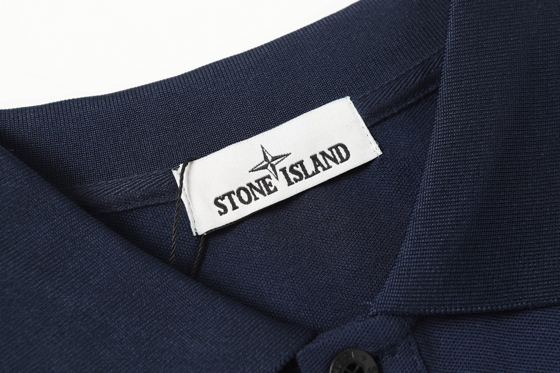Navy polo shirt neckline with woven brand tag and top button