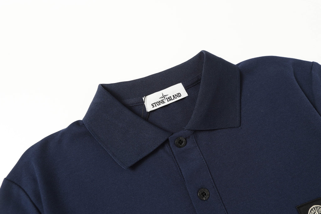 Navy polo shirt close-up showing spread collar and button placket
