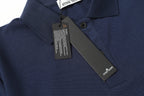Navy polo shirt close-up with collar buttons and diagonal chest brand label