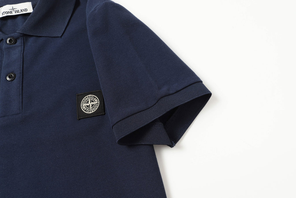 Navy polo shirt sleeve cuff detail with chest logo patch