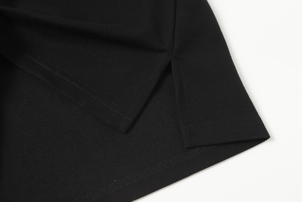 Black polo shirt side seam with stitched hem