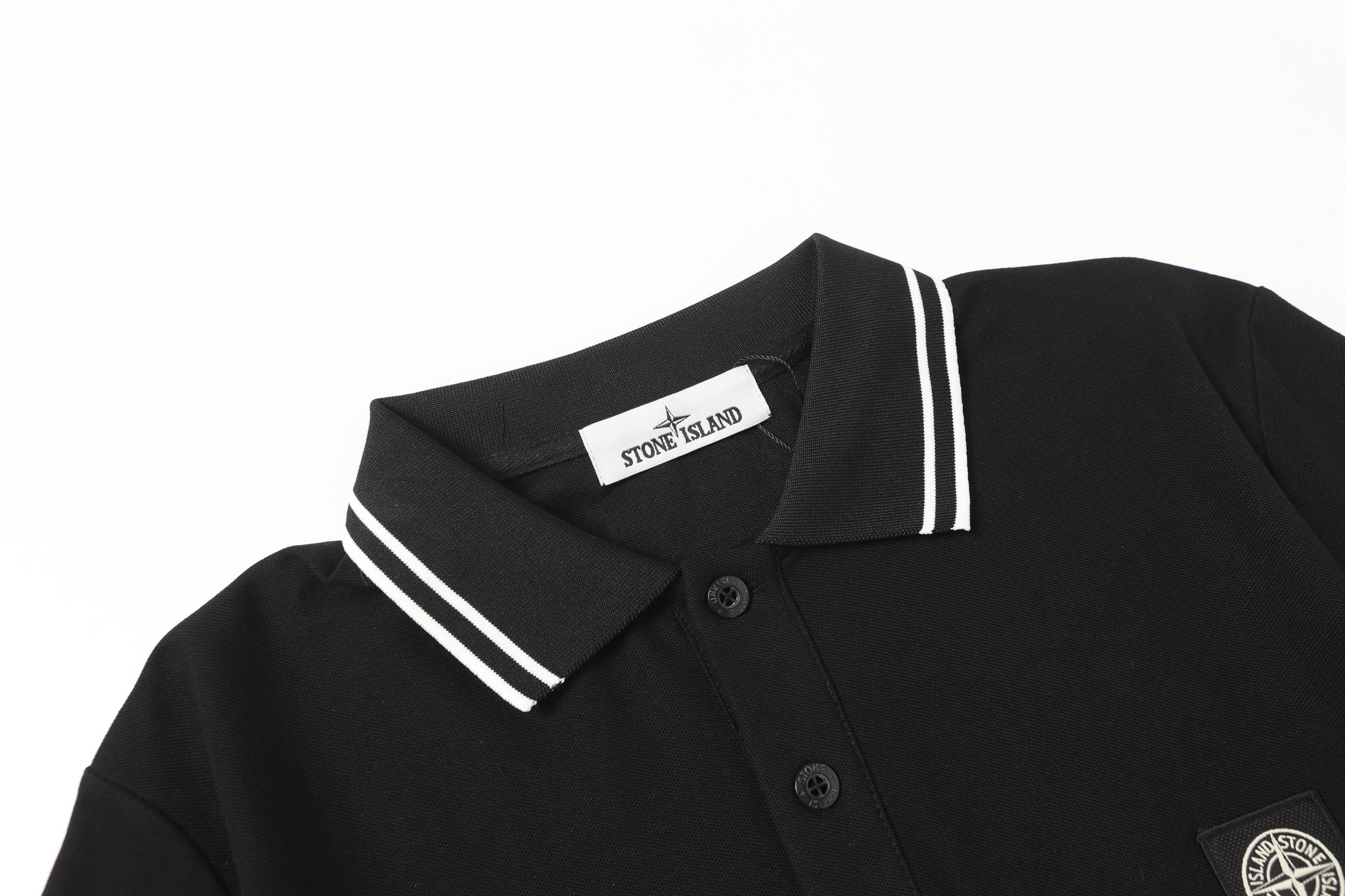 Black polo shirt with striped collar, button placket, and chest patch