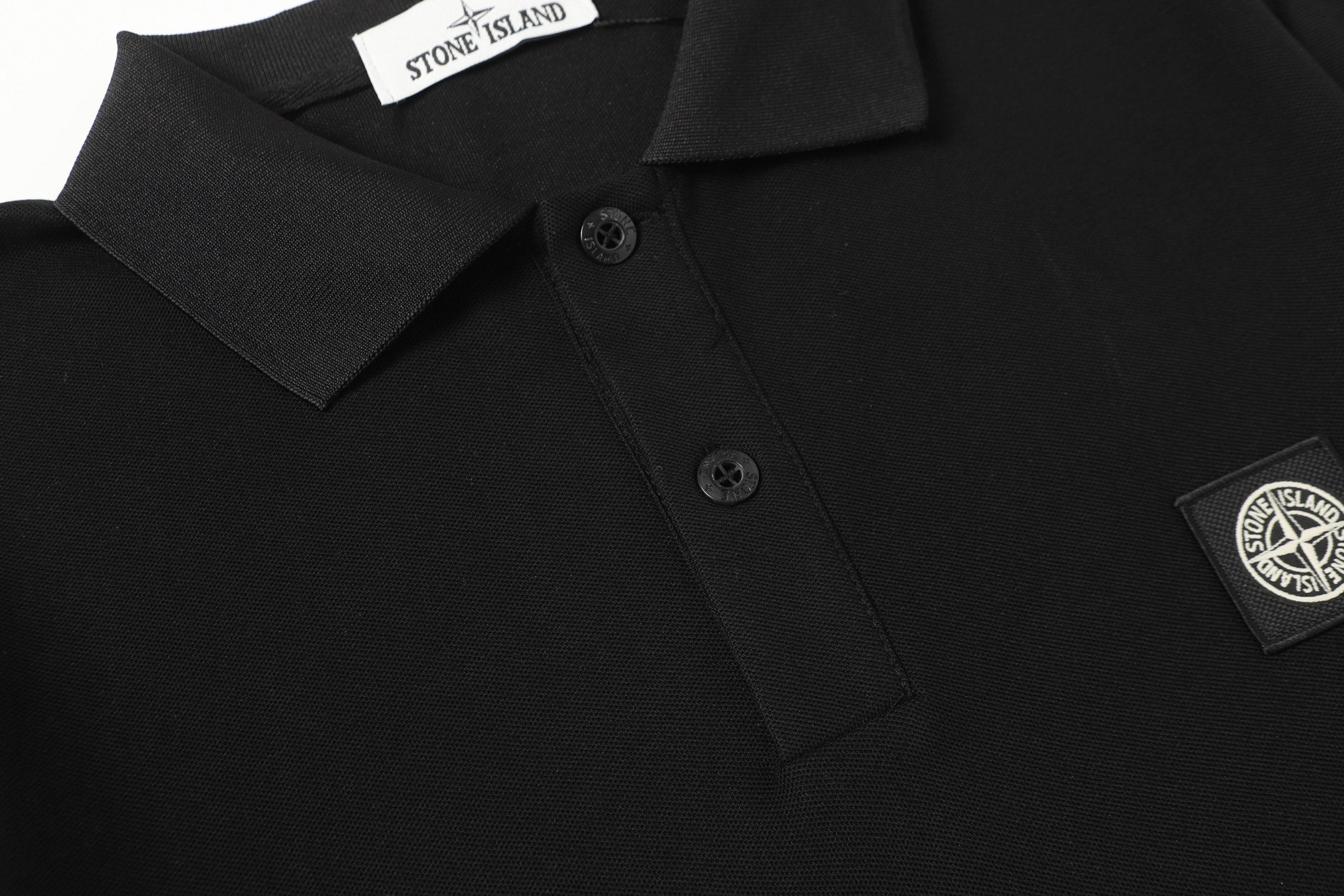 Black polo shirt with short button placket and chest logo patch