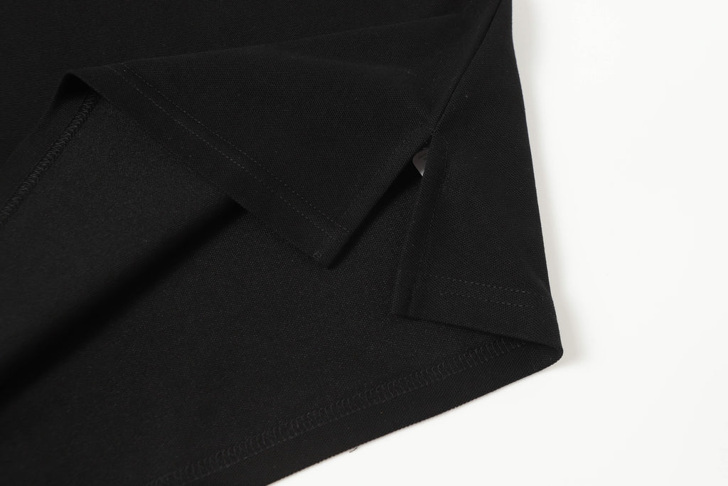 Black polo shirt hem and sleeve seam details