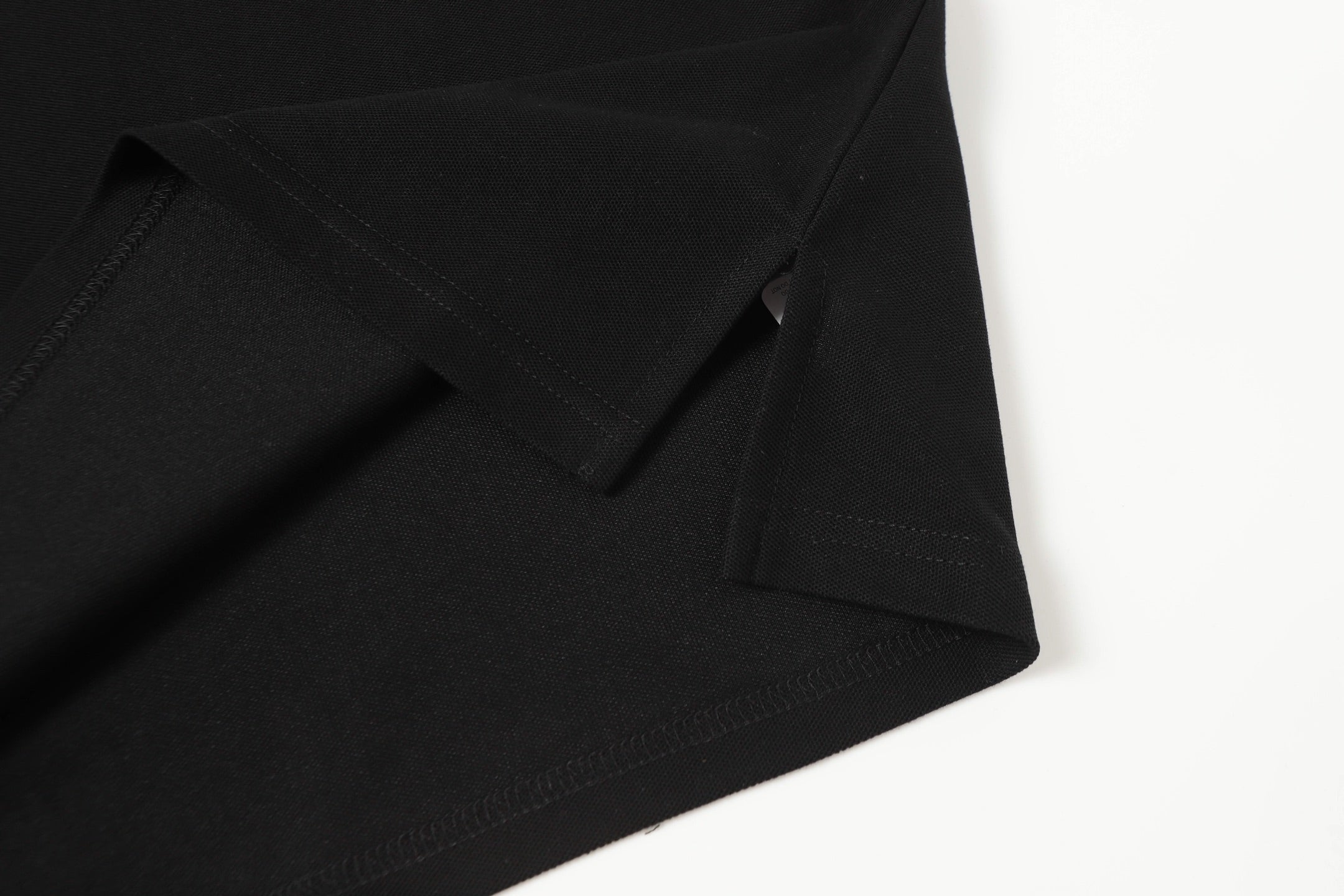 Black polo shirt hem and sleeve seam details