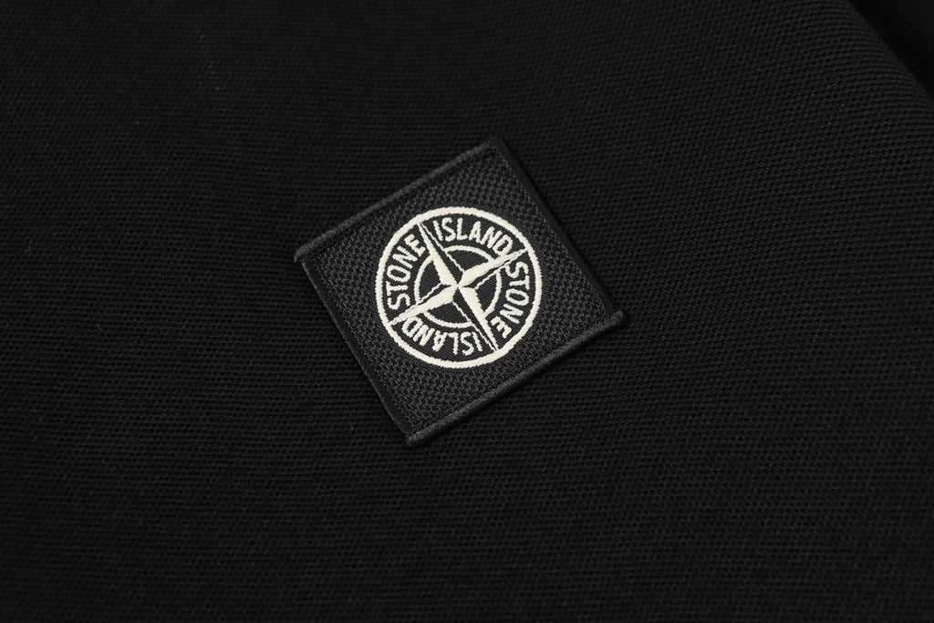 Stone Island logo patch on black textured fabric