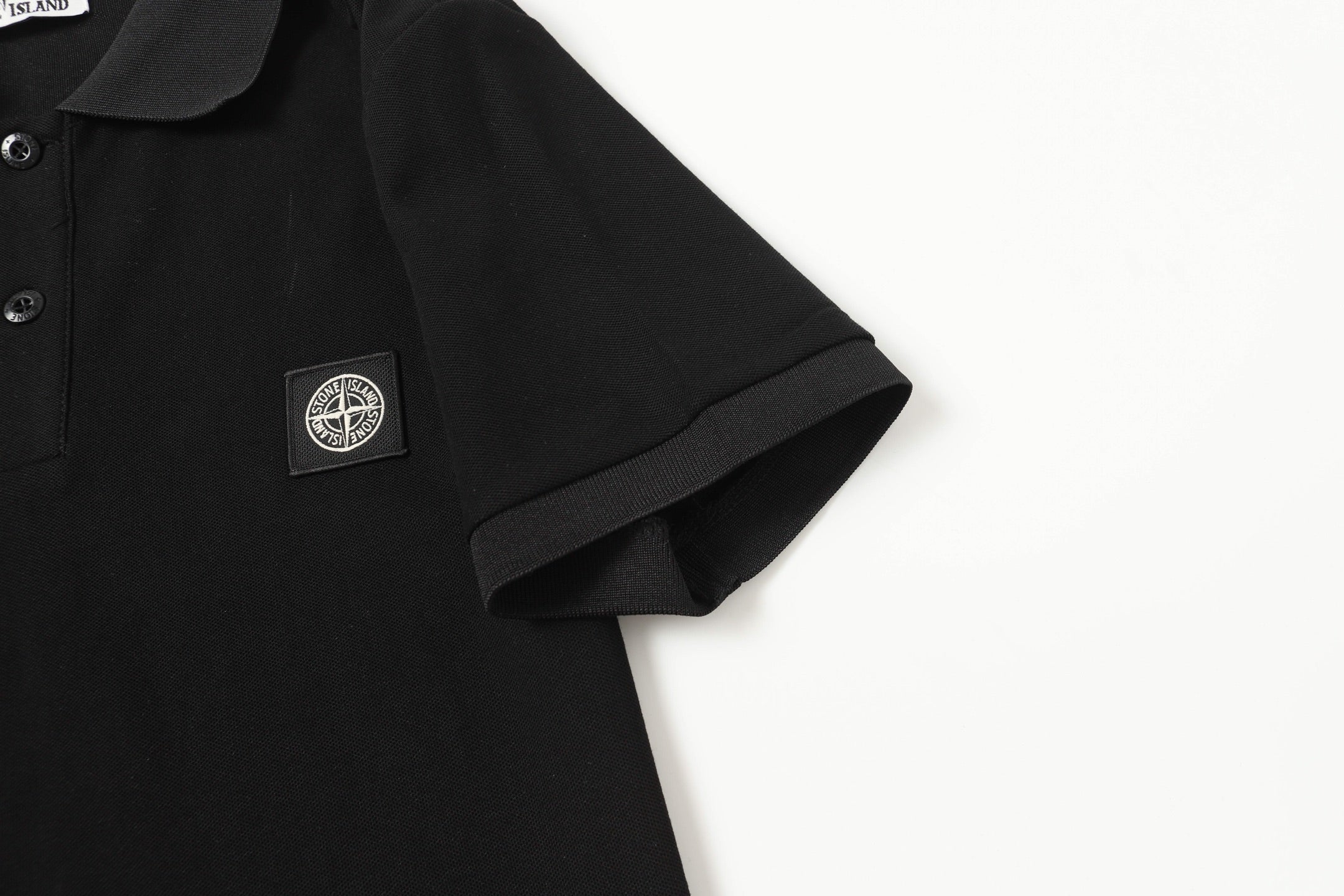 Black polo shirt sleeve and chest logo patch
