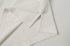 White polo shirt fabric close-up with stitched hem and sleeve