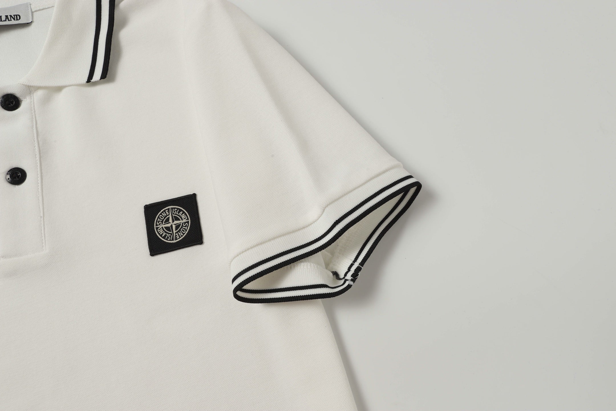 White polo shirt sleeve cuff with black striped trim