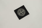 Black woven logo patch on white fabric