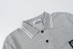 Light gray polo shirt neckline with two-button placket and striped collar