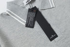 Light gray polo collar close-up with striped trim and black hang tag