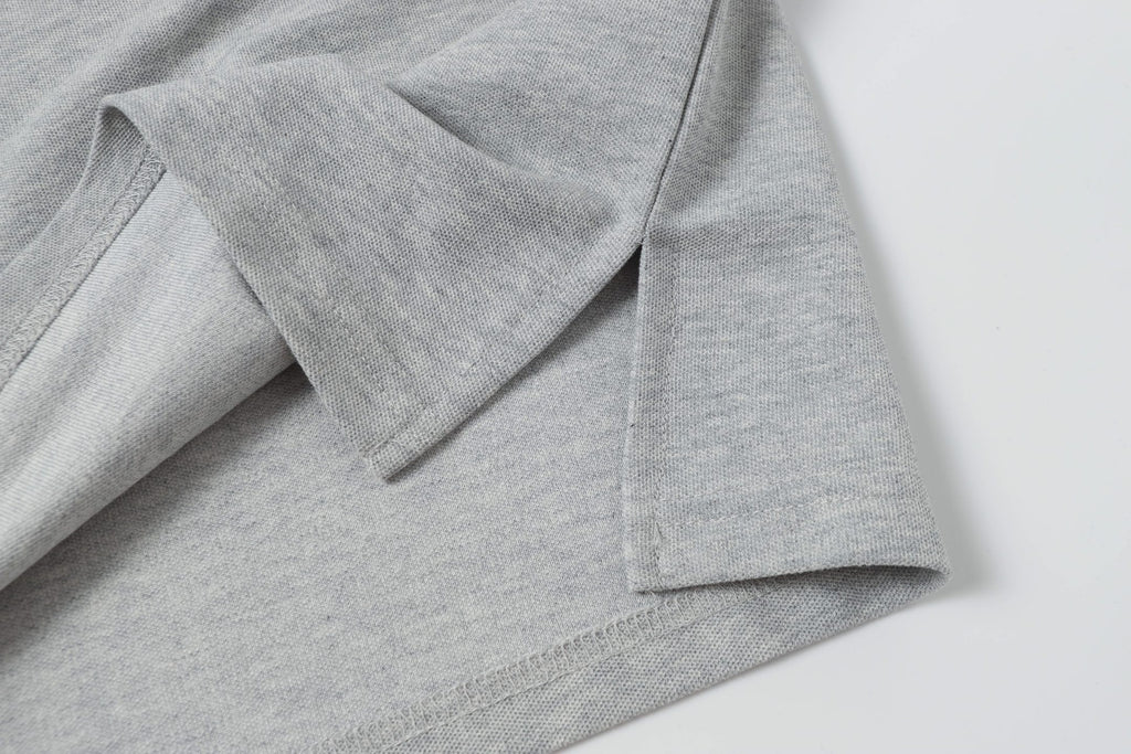 Light gray polo shirt side detail with seam and folded fabric