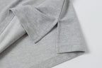 Light gray polo shirt side detail with seam and folded fabric