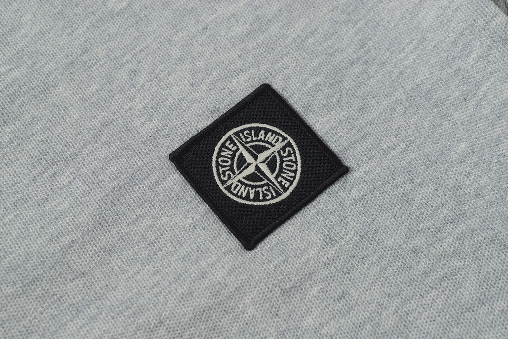 Stone Island patch logo on light gray polo fabric