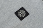 Stone Island patch logo on light gray polo fabric