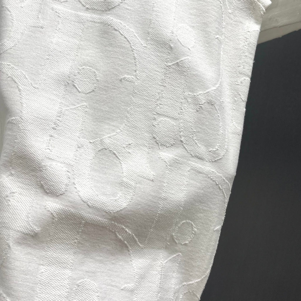 White Dior short-sleeve T-shirt close-up showing raised embossed pattern texture