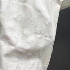 White Dior short-sleeve T-shirt close-up showing raised embossed pattern texture